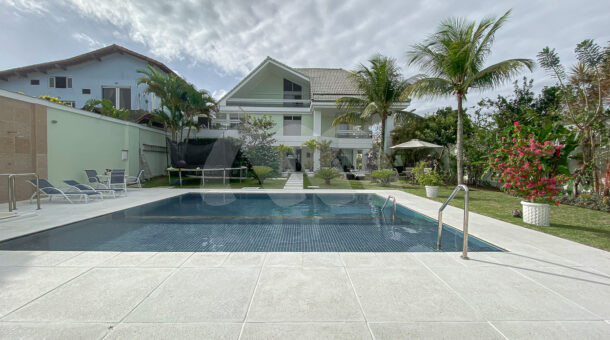 Imagem piscina com borda infinita e casa triplex da casa à venda em condomínio de alto padrão.