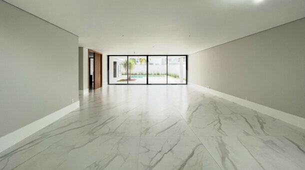 Sala com piso porcelanato branco, paredes cinzas e portas de vidro, à venda no Alphaville