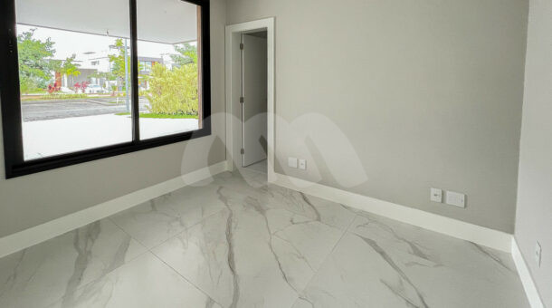 Quarto cinza com piso de porcelanato branco e janela grande, à venda na barra da tijuca