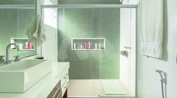 Imagem do banheiro com chuveiro e box verde da casa à venda na Barra da Tijuca. Casas à venda