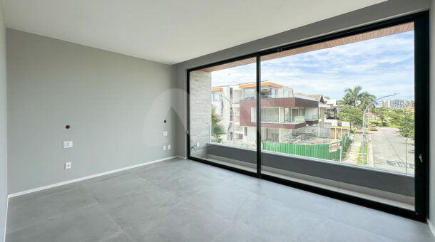 quarta suíte com piso e parede cinza com a vista para a área externa no condomínio, à venda na barra da tijuca