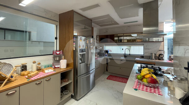 Imagem lateral da cozinha com vista ampla da casa à venda em prestigioso condomínio.