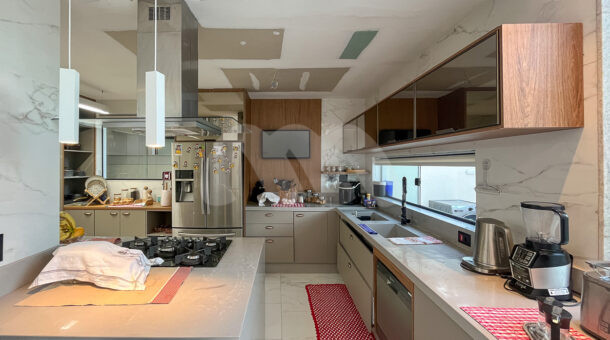 Imagem da cozinha com vista do balcão e da geladeira da casa de luxo à venda.
