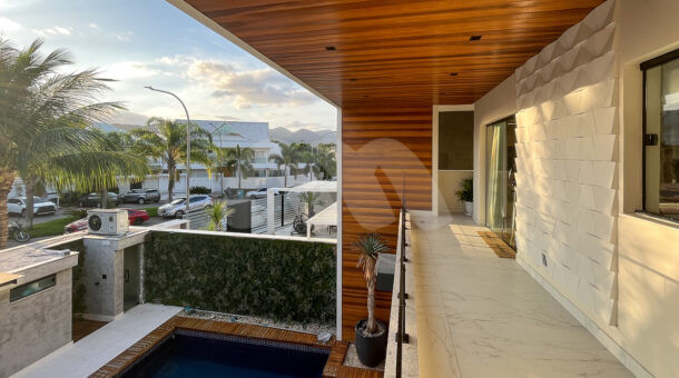 Imagem lateral da varanda com vist externa da casa da casa moderna à venda na Muller Imóveis RJ.