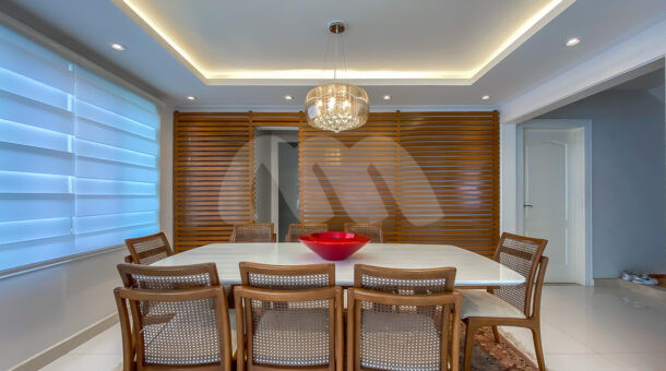 Imagem de sala de jantar com mesa em vidro off white e cadeiras com palha indiana da belissima casa no Barra RJ.