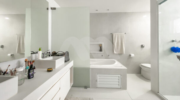 Imagem de banheiro com pia dupla, banheira de hidromassagem e chuveiro com box da casa triplex à venda na Muller Imóveis RJ