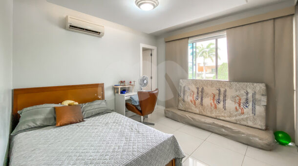 Imagem de quarto com cama de casal em madeira e escrivaninha da casa moderna na Barra da Tijuca RJ.