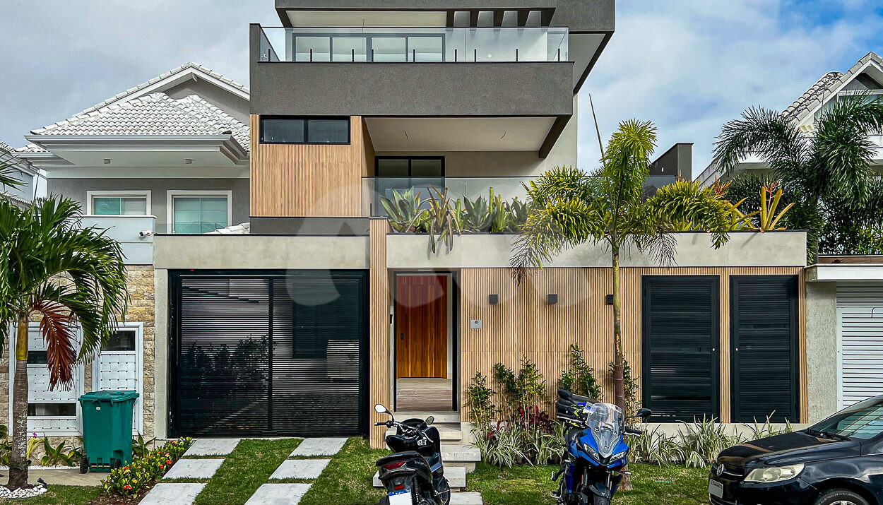 Imagem frontal com vista da garagem e da casa no condomínio Riviera Del Sol.