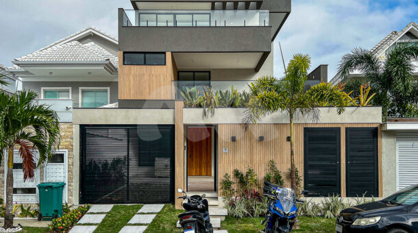 Imagem frontal com vista da garagem e da casa no condomínio Riviera Del Sol.