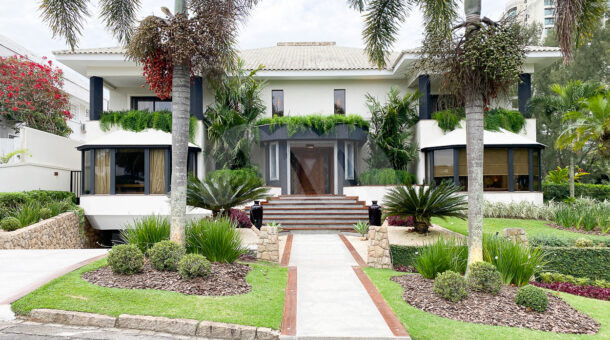Fachada de Casa Duplex atemporal à venda na Barra da Tijuca, com belo paisagismo