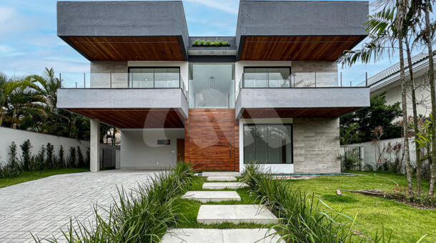 Imagem da fachada com gramado e sacadas da casa de alto padrão à venda no Quintas do Rio. Imobiliária RJ