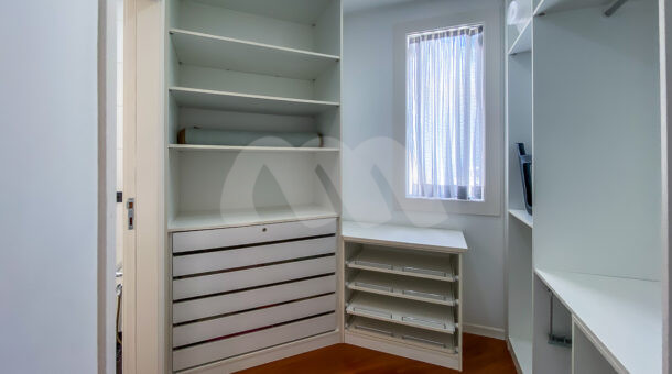 closet da suite com piso de madeira e armários