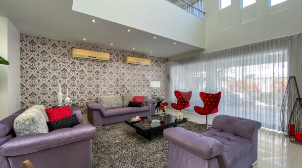 terceiro ambiente da sala, com tres sofás e mesa de central, 2 ar-condicionados e papel de parede