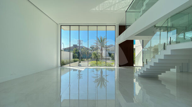 Sala da casa contemporânea divididas em vários ambientes com portas de vidro e vista para a área externa da frente da casa