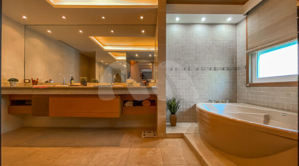 Amplo banheiro da suíte master com banheira de hidromassagem e cuba dupla