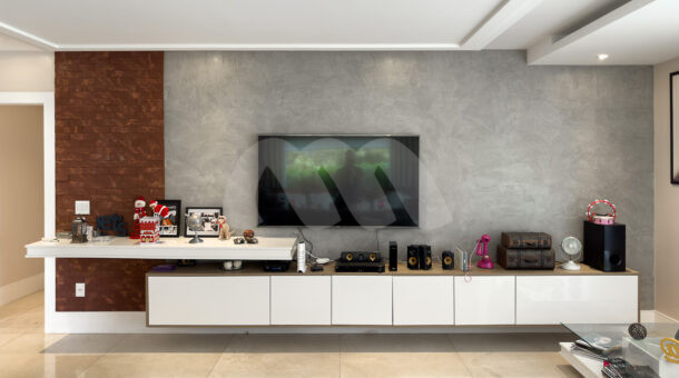 Sala de TV com parede em cimento queimado e tijolinhos, com rack e prateleiras, estilo moderno