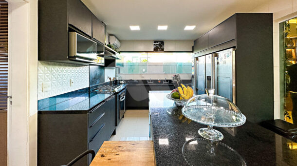 Cozinha com móveis planejados na cor preta e uma ilha