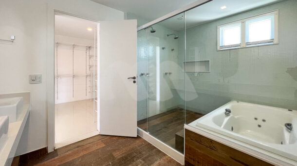 Banheiro suíte master - vista de acesso ao closet e área de banho - Muller Imóveis