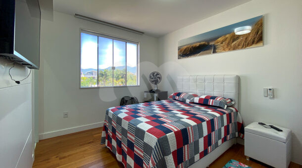 Imagem lateral do quarto com vista da cama de casal da casa moderna à venda na Muller Imóveis RJ.