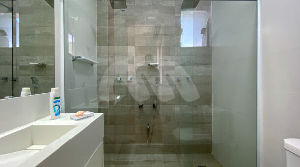 Imagem do banheiro com vista do box com duplo chuveiro da casa à venda em condomínio de alto padrão.