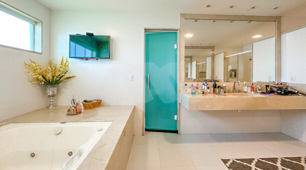 banheiro da suite master com banheira de hidromassagem e pia de mármore
