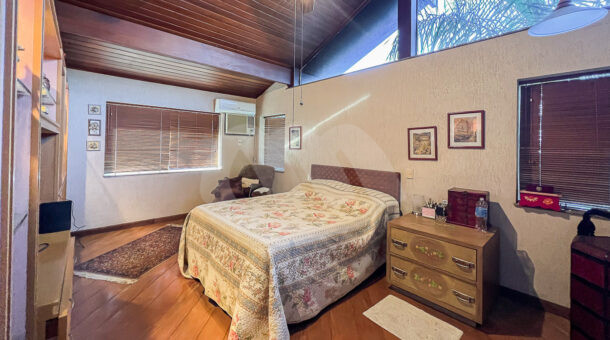 imagem da primeira suíte com móveis planejados da casa duplex com clima rústico à venda na Barra da Tijuca na imobiliária de luxo RJ