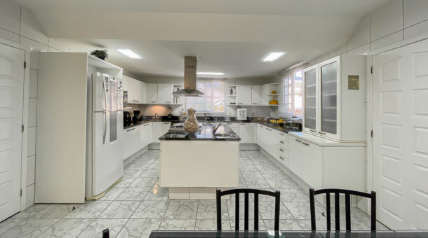 imagem da cozinha com ilha da casa Triplex próximo à praia à venda na Barra da Tijuca na imobiliária de luxo RJ