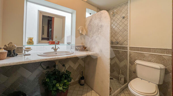 imagem do banheiro da primeira suíte da casa duplex com clima rústico à venda na Barra da Tijuca na imobiliária de luxo RJ