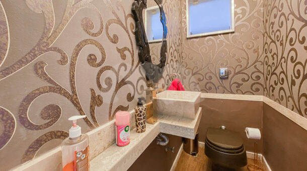 Imagem do banheiro com detalhes marrom da mansão moderna à venda na Muller Imóveis RJ.