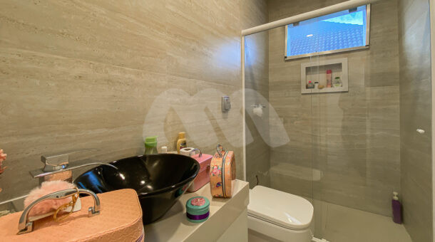 Imagem lateral do banheiro com vista da casa à venda em condomínio de alto padrão.
