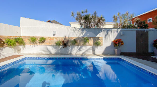 imagem da área externa com piscina e paisagismo da casa Triplex próximo à praia à venda na Barra da Tijuca na imobiliária de luxo RJ