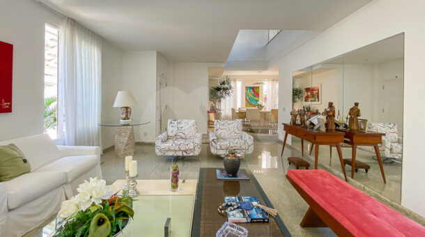 imagem da sala com sofás e poltronas da casa Triplex próximo à praia à venda na Barra da Tijuca na imobiliária de luxo RJ