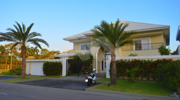 Imagem de fachada de casa com paisagismo em casa triplex a venda na Barra