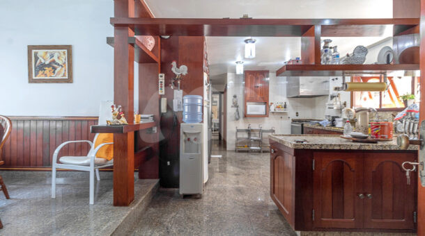 Imagem da cozinha com moveis de madeira da casa duplex à venda no Pedra de Itaúna, na Barra da Tijuca