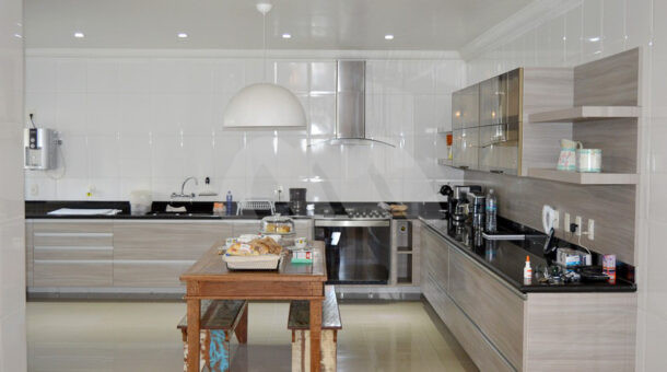 Imagem de cozinha ampla com armario planejado e mesa de cafe da manha da casa triplex