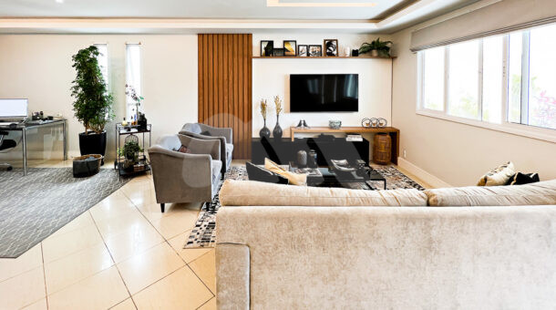 Imagem da sala com tv da casa Duplex com placas fotovoltaicas à venda na Barra da Tijuca