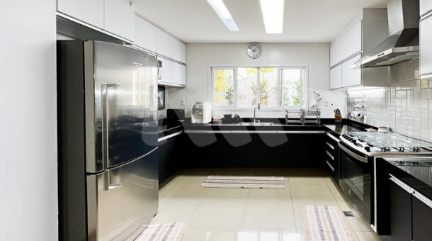 Imagem da cozinha com ampla bancada com armário planejado da casa Duplex com placas fotovoltaicas à venda na Barra da Tijuca