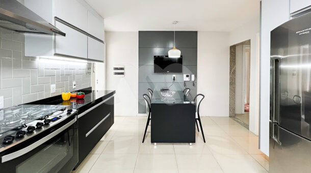 Imagem da cozinha com televisão da casa Duplex com placas fotovoltaicas à venda na Barra da Tijuca