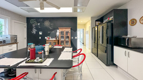 Imagem da cozinha com móveis planejados da casa duplex no Novo Leblon à venda na Barra da Tijuca