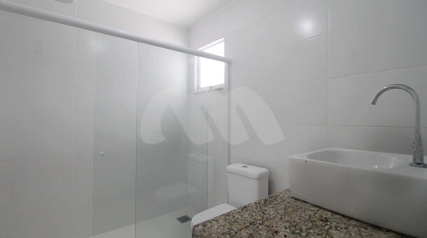 Imagem lateral do banheiro com vista da pia do imóvel à venda na imobiliaria Muller Imóveis RJ.