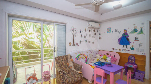 Imagem do quarto infantil com detalhes em rosa do imóvel de luxo à venda.