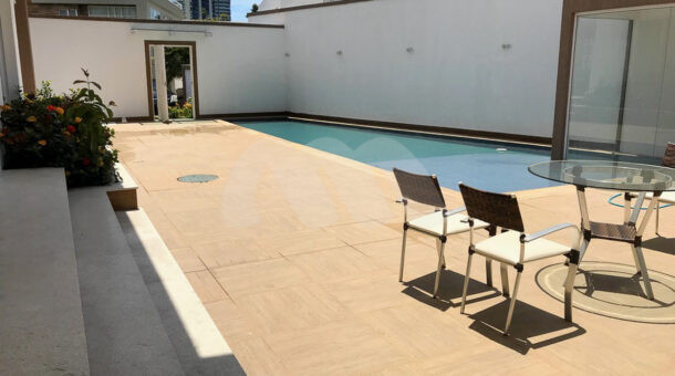 Imagem latertal da área de lazer com piscina da casa à venda no Recreio dos bandeirantes.