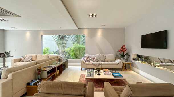 Imagem de sala de tv com poltronas e sofás em casa triplex