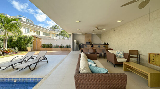 Imagem de varanda com sofá e poltronas em area gourmet de casa triplex a venda