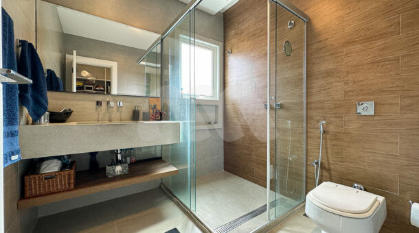 Imagem de banheiro de suite com bancada e box com chuveiro no teto da casa triplex a venda