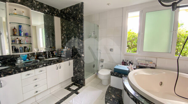 Imagem lateral do banheiro da suite da casa à venda em condomínio de alto padrão.