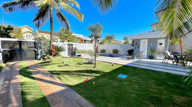 Imagem do quintal com gramado e paisagismo da casa Duplex com placas fotovoltaicas à venda na Barra da Tijuca