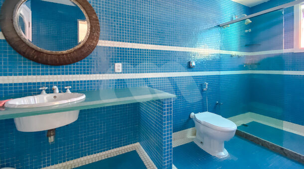 Imagem frontal do banheiro azul com vista da pia da mansão contemporânea à venda.
