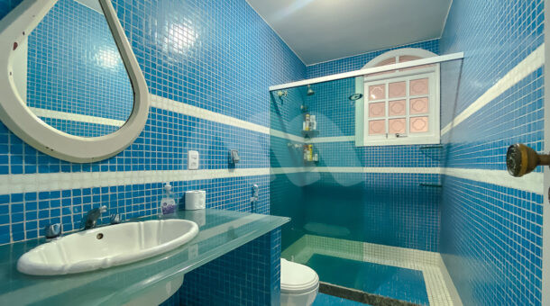Imagem lateral do banheiro com detalhes azul e branco da casa à venda em prestigioso condomínio.
