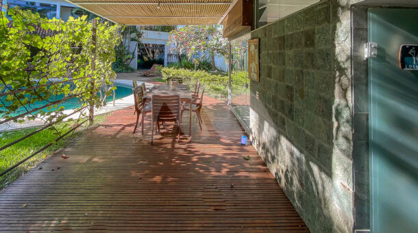 Imagem de varanda com deck de madeira e mesa de area externa em casa triplex de alto padrao a venda no condominio mandala